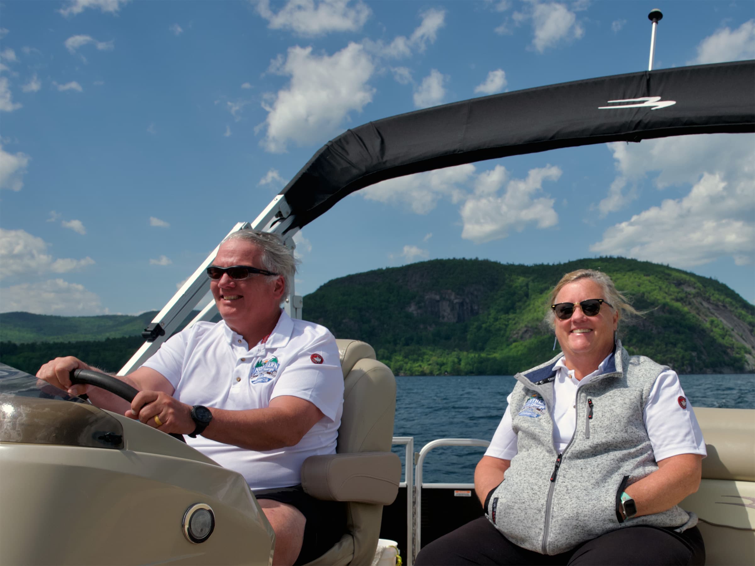 Tom and Amanda on the boat with Lake George mountains behind them